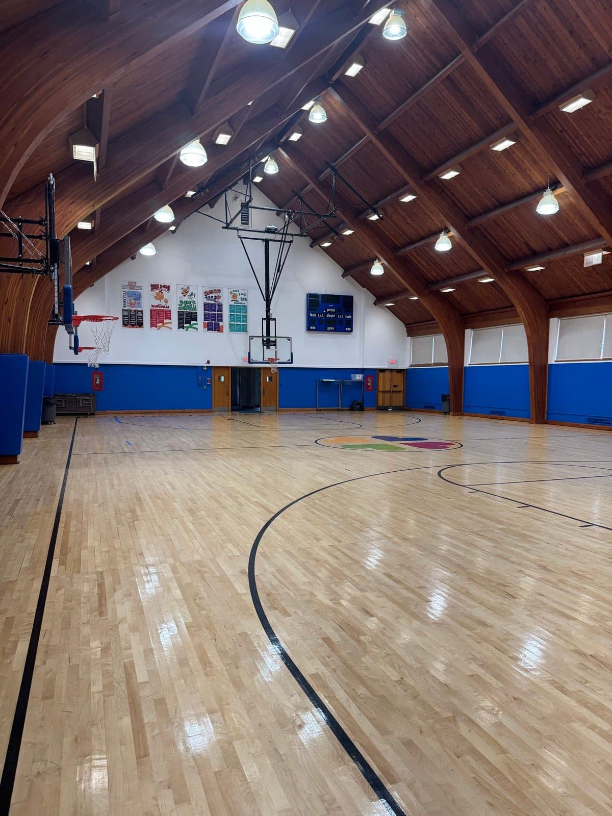 The Reformed Church of Bronxville gym, with a timber cathedral ceiling and a colorful logo at center court