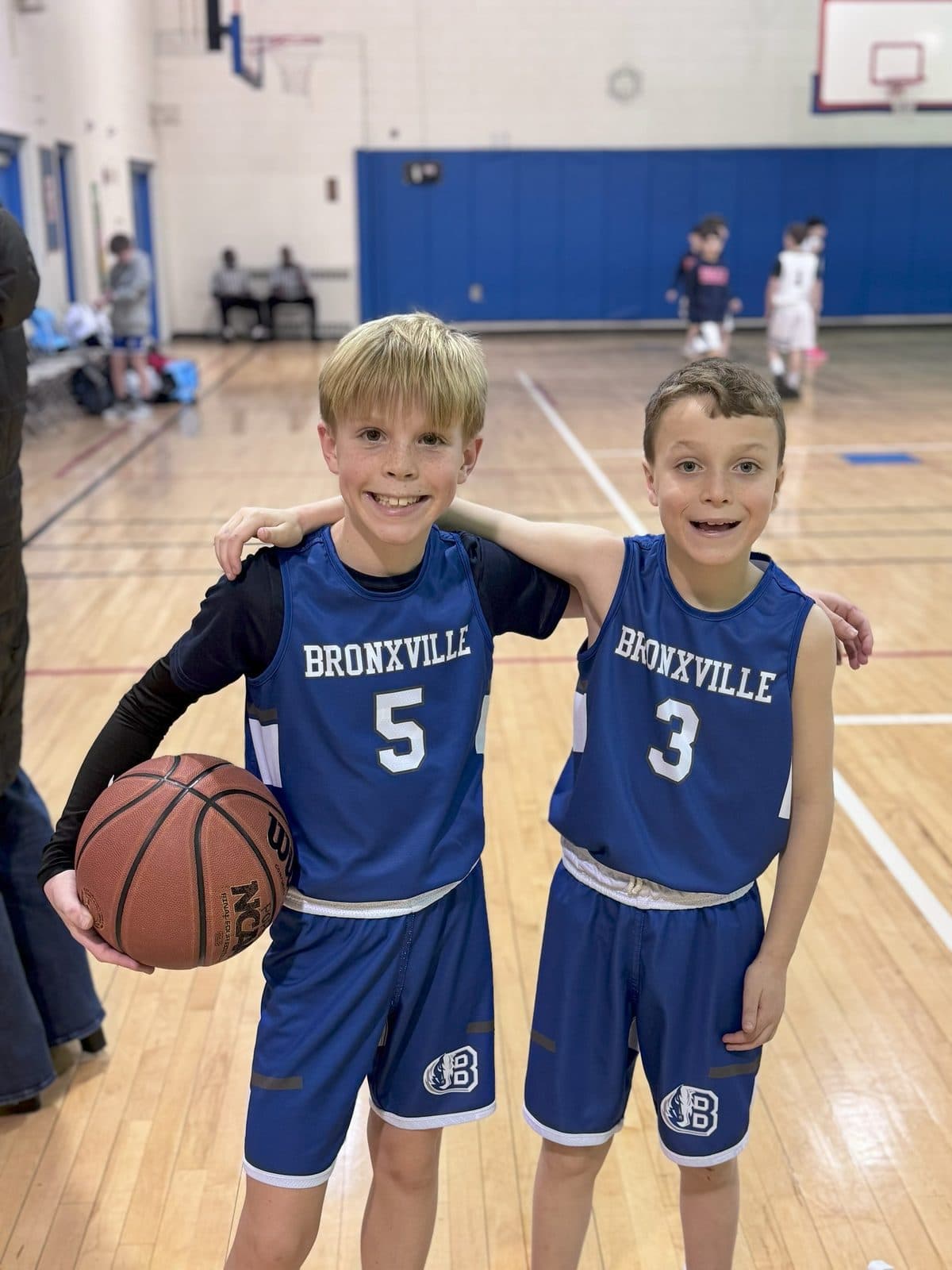 Two young Bronxville Broncos posing with the ball at a game