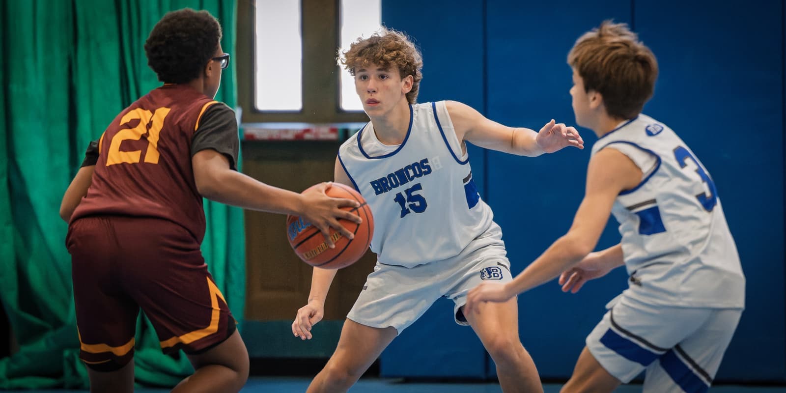 A Bronco playing on-ball defense in a travel game