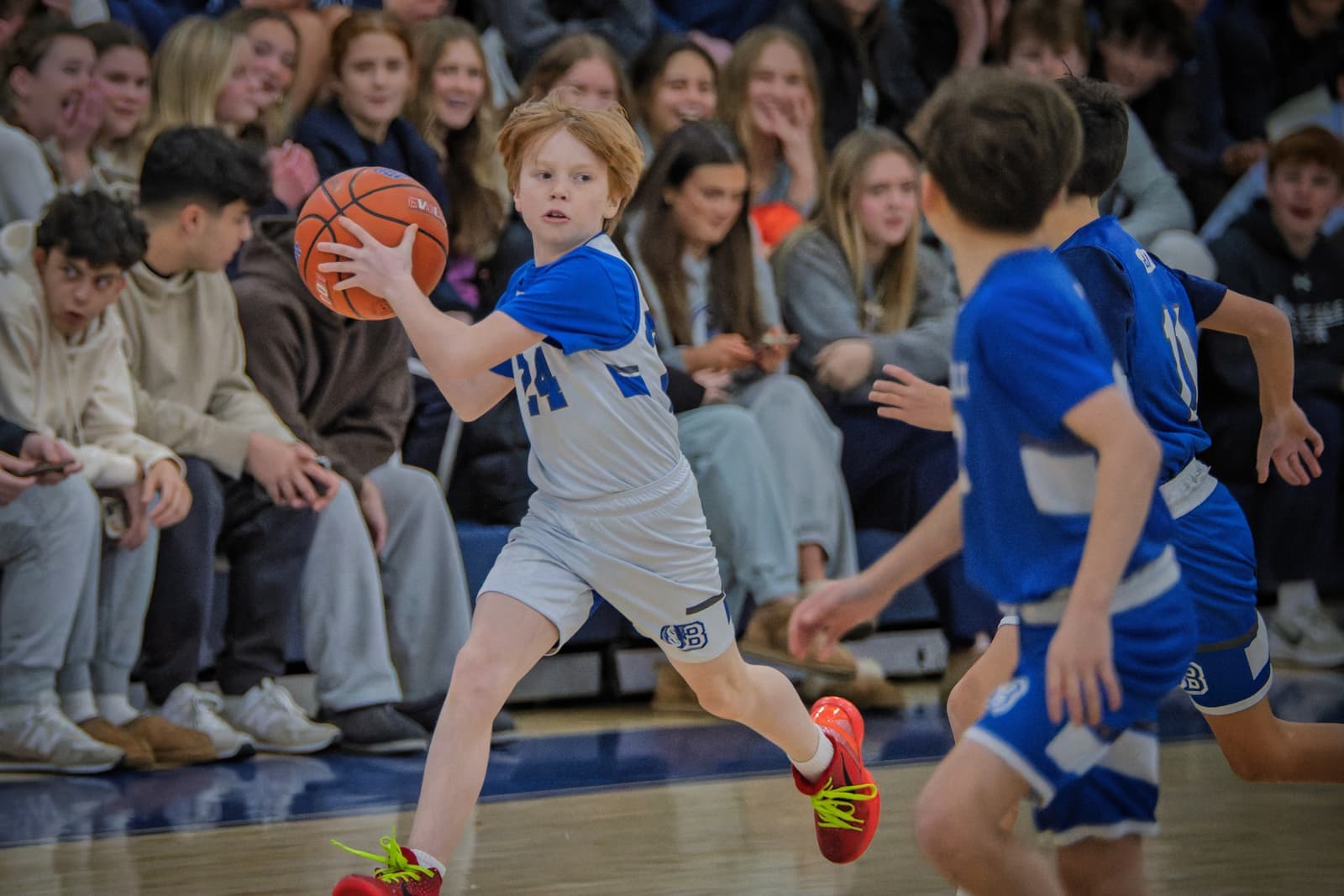 A Bronco pushing the ball upcourt in front of a packed crowd