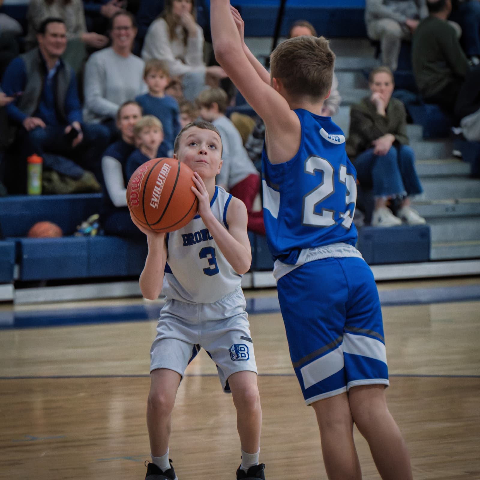 A young Bronco eyeing the basket against a taller defender