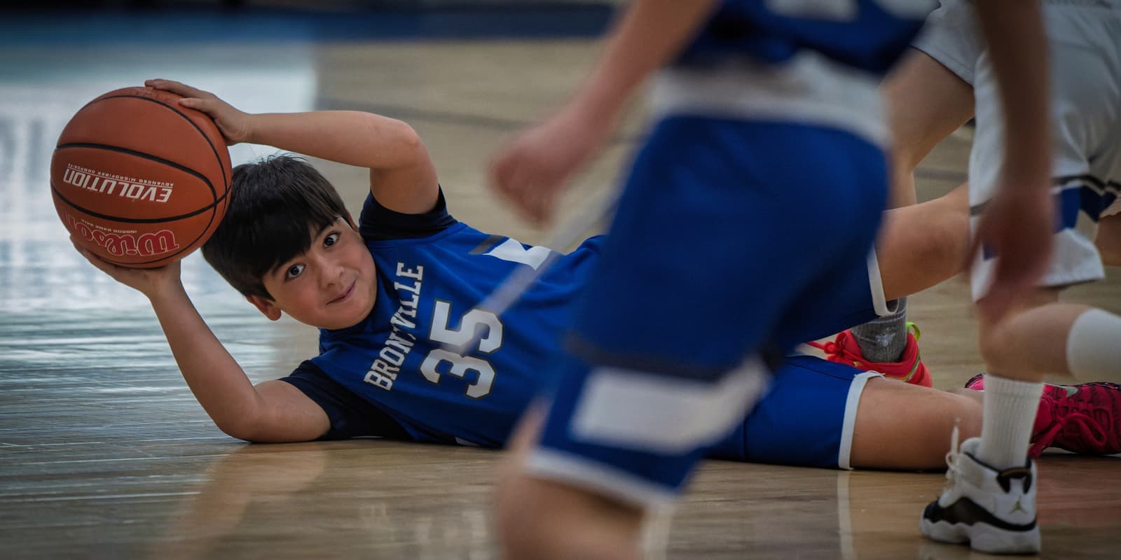 A Bronxville player protecting a loose ball on the floor