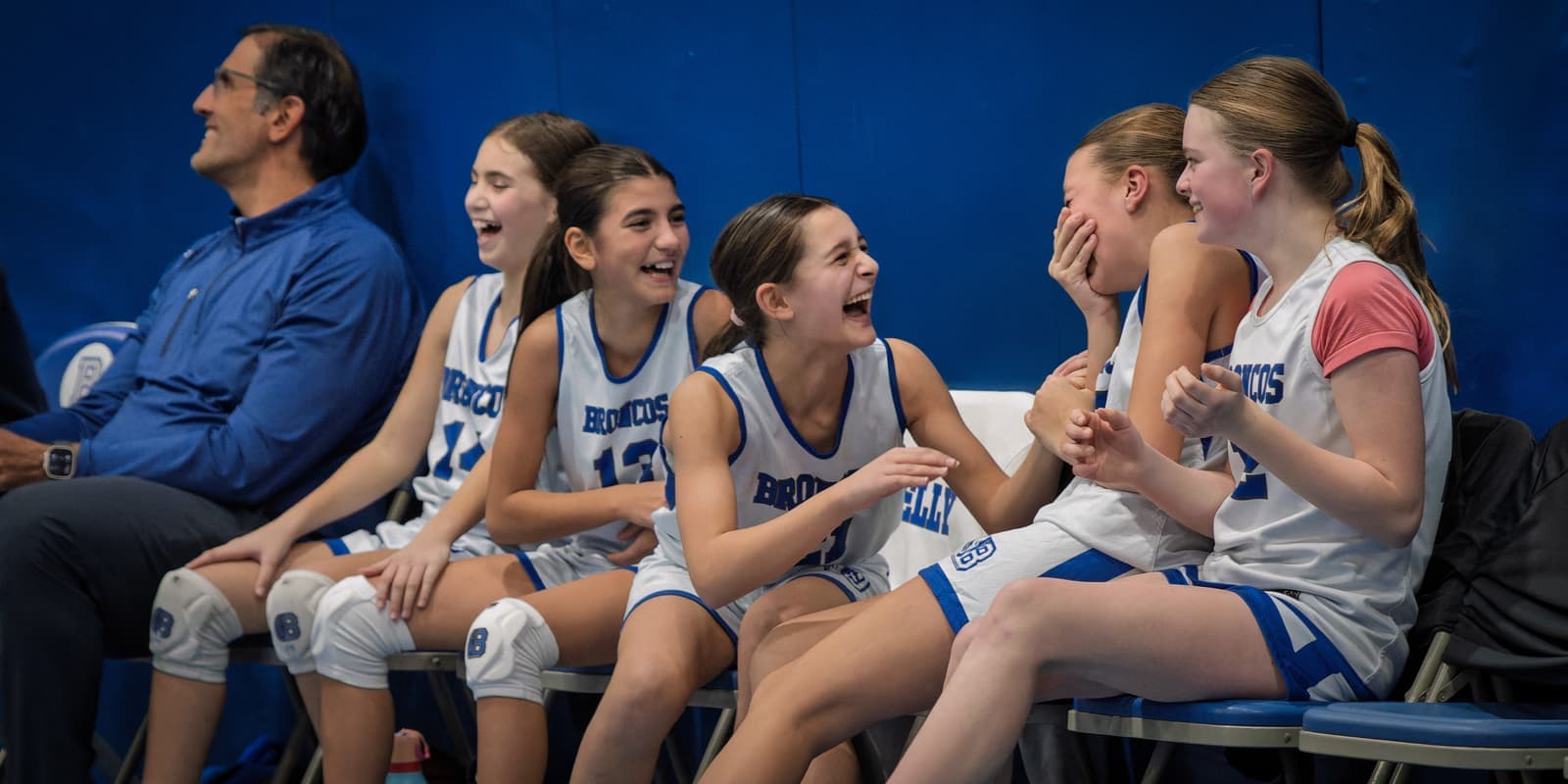 BYBA girls sharing a laugh on the bench