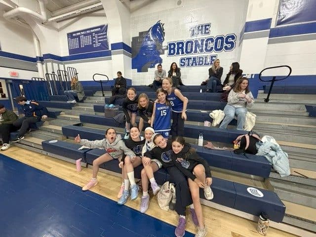 A BYBA girls team hanging out in the Broncos Stable bleachers