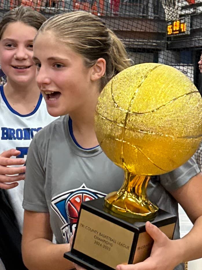 A BYBA girl celebrating with the championship trophy