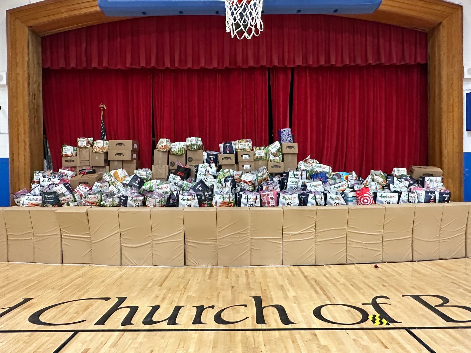 Hundreds of packed meal boxes stacked on the stage at the Reformed Church of Bronxville gym
