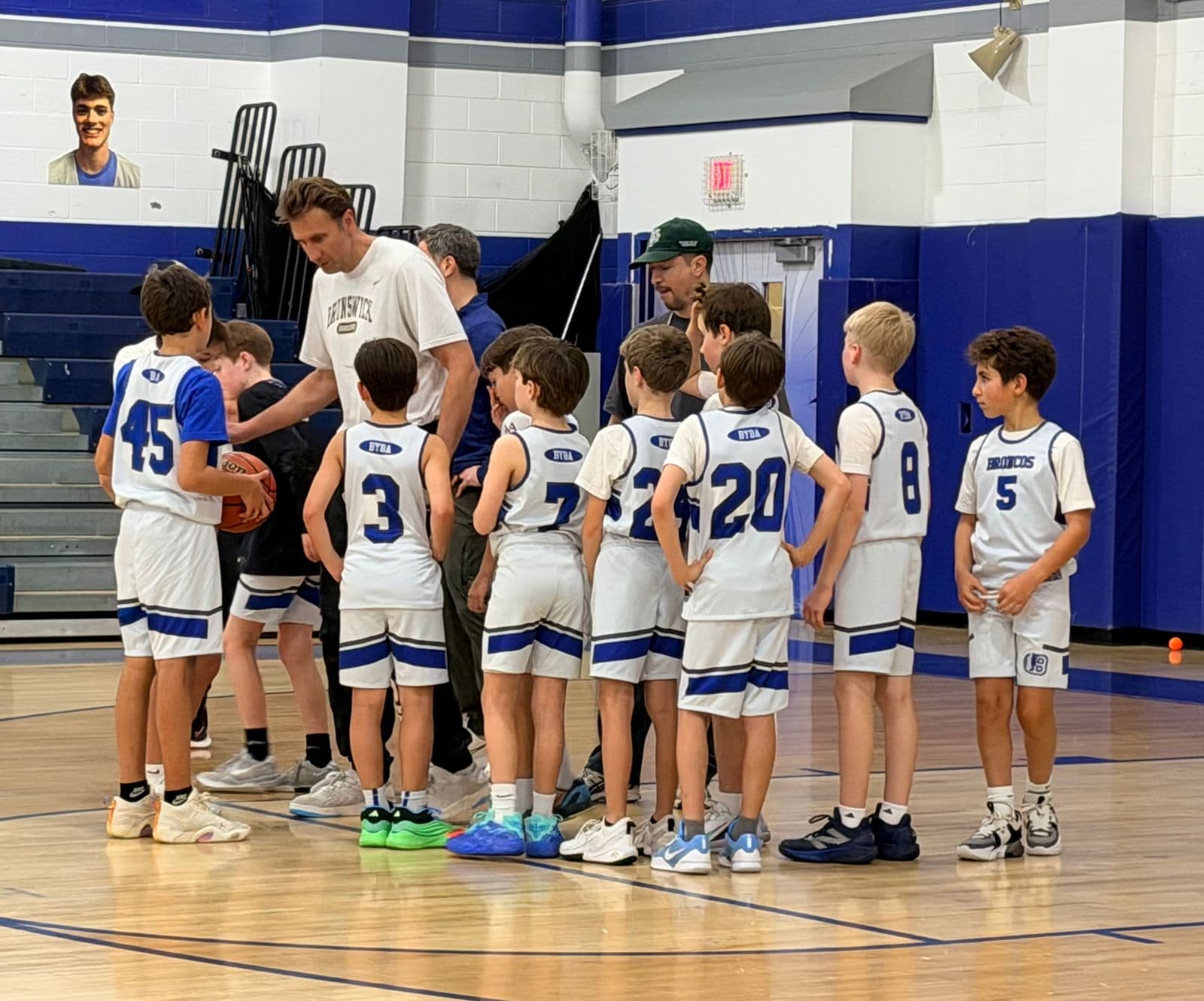 A BYBA team huddling with their coach